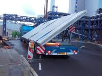 Transport van grote betonplaten op een schuinstelling.